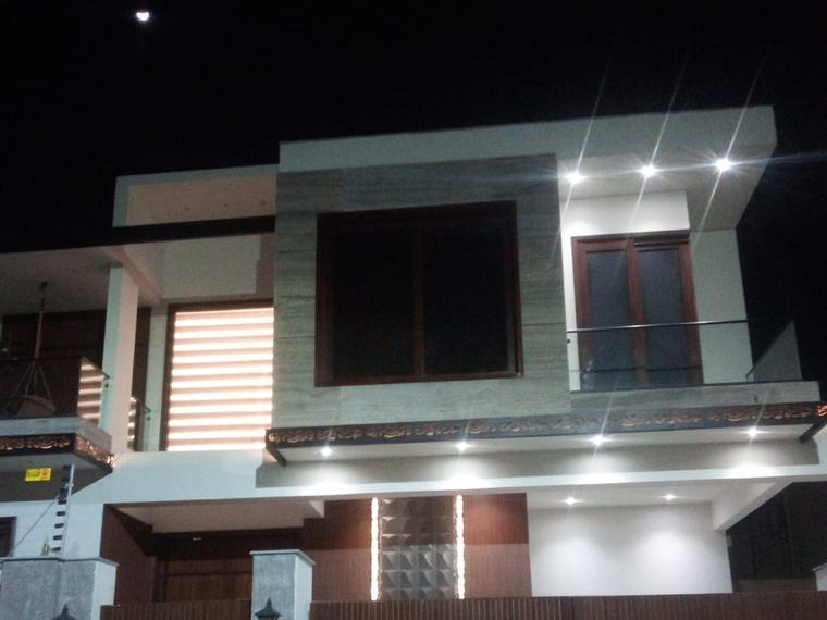 Modern two-storey bungalow exterior at night